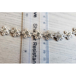 Rhinestones trim- daisies, placed on a grey background with the ruler