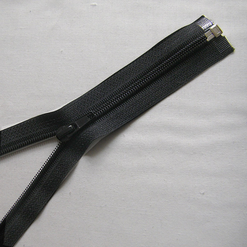 Open-ended plastic coil zip - black - 40cm long on a grey background