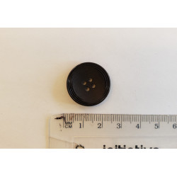 Large, black suit button with the ruler on a white background