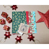 Layer Cake - Christmas metallic fabric bundle, placed on a natural background with some Christmas decorations gathered around