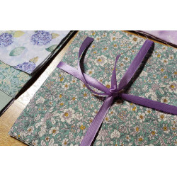 Sage&Lilac colors mood- Layer cake fabric bundle placed across the frame