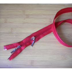 double slider plastic  zip - red - 45 cm long, placed on a wooden background across the frame