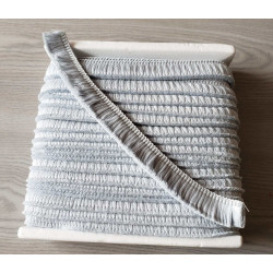 Short cotton fringe 3cm - pale blue, full reel of the fringing placed on a grey table