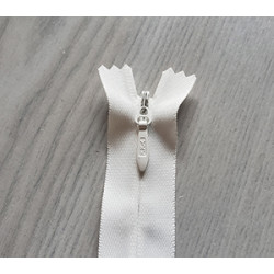 invisible zip size 5 - off white - 55cm long, placed on a grey background, close up on the zip slider