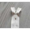 invisible zip size 5 - off white - 55cm long, placed on a grey background, close up on the zip slider