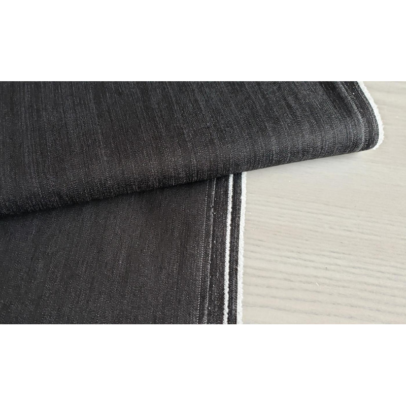 stretch denim fabric  - black color, placed on the table with the fold