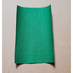 Iron-on  repair fabric in an intense green color. the sheet placed on a beige background