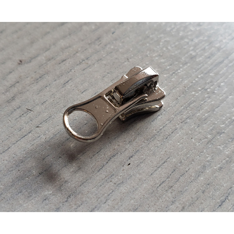 zip slider- chunky- size 3 - silver - short puller, plac3ed on a wooden table