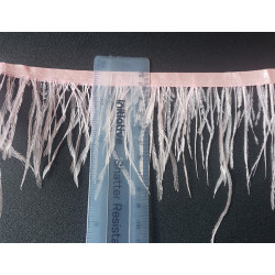 Ostrich feather fringe trim- light pink color, placed with the ruler on a black, contrasting background