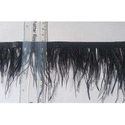 Ostrich feather fringe trim- black color, placed with the ruler on a white, contrasting background