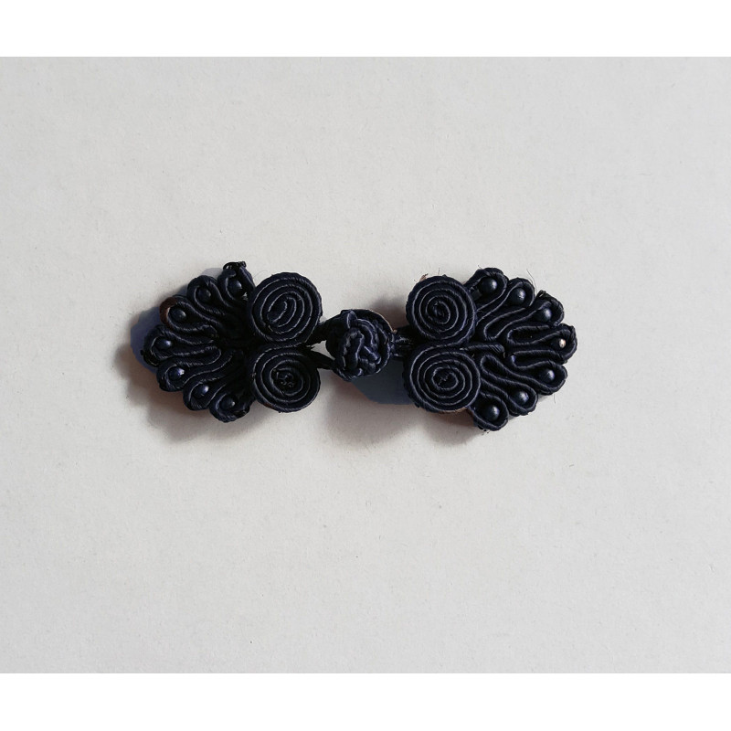 Frog fastener- black with beads, placed on a white background