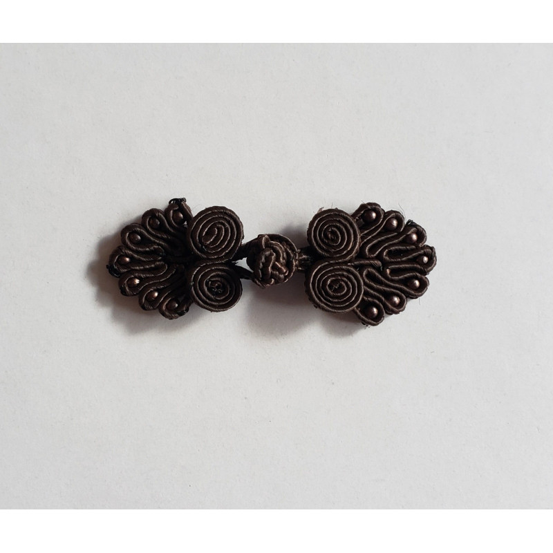 Frog fastener- dark brown with beads, placed on a white background
