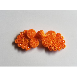 Frog fastener- orange with beads, placed on a white background
